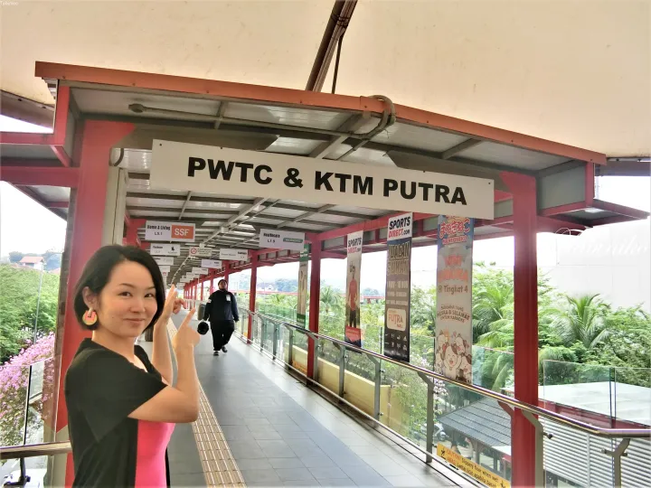 PWTC & KTM Putra駅のエントランスでポーズを取る女性。